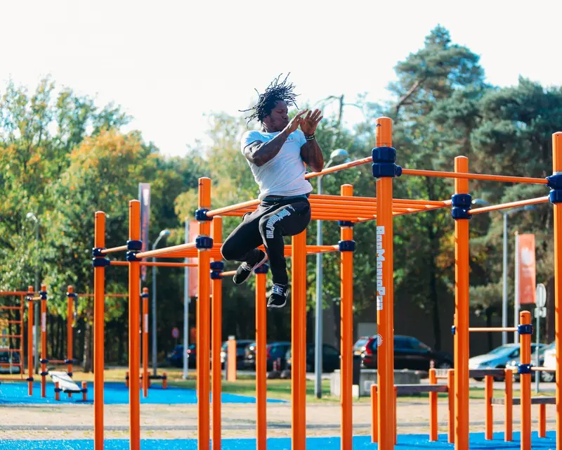 Atleta entrenando en las barras de un parque de calistenia